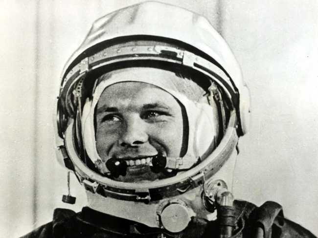 a tight shot on a young Yuri Gagarin smiling inside his spacesuit